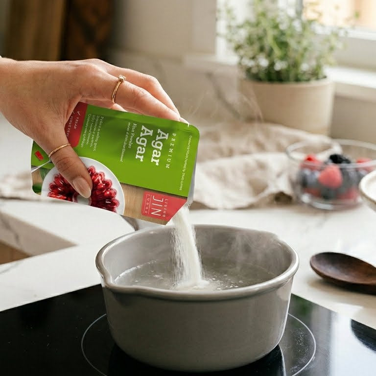 A person pouring Livingjin pure agar agar powder into a simmering pot, preparing a healthy plant-based vegan alternative to traditional animal gelatin.