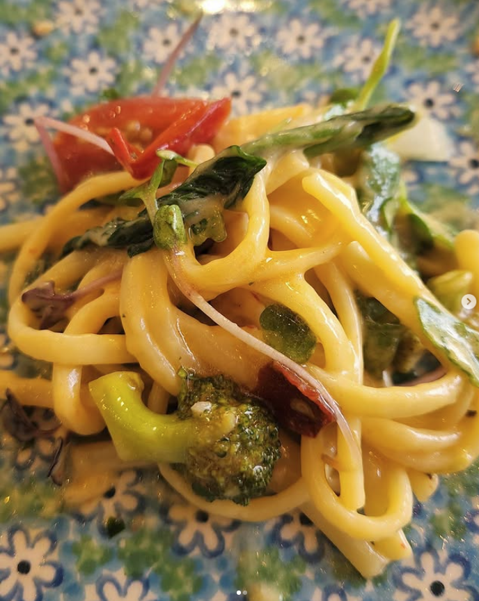 Pasta dish with vegetables on a patterned plate