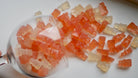 Gummy bears in a clear container on a white surface