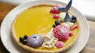 Decorative tart with mermaid-themed decorations on a white plate.